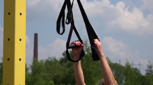 A Fit Beautiful Woman Does Assisted Squats at an Outdoor Gym - Closeup