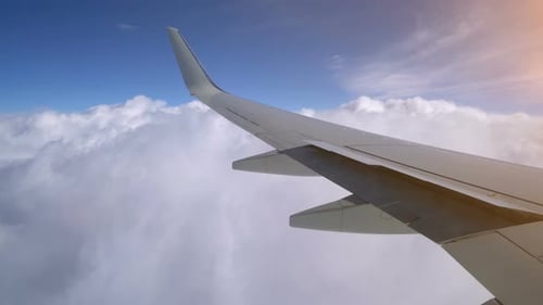 Aile d'un avion volant au-dessus des nuages