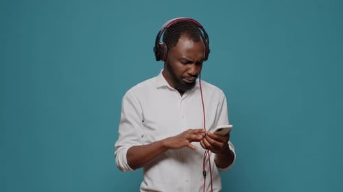 Young Person Listening to Sound on Headphones with Mobile Phone