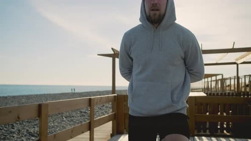 Man Doing Lunges on Boardwalk at Beach