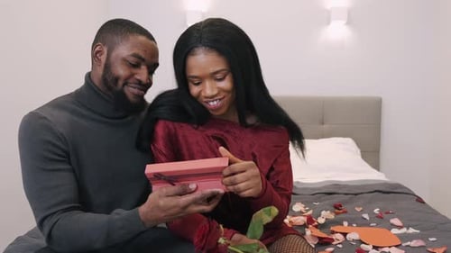 Loving Couple Celebrating Anniversary with Gift and Rose