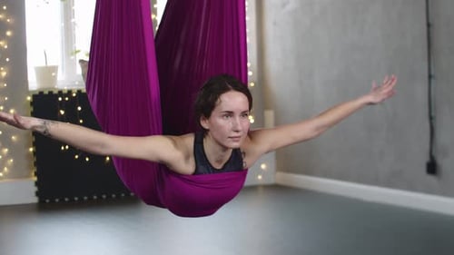 Woman Practicing Aerial Yoga in Hammock