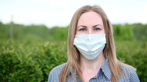Portrait of a Girl Blonde in a Mask. Covid-19 Virus Pandemic in China. Pneumonia, H1N1 Influenza
