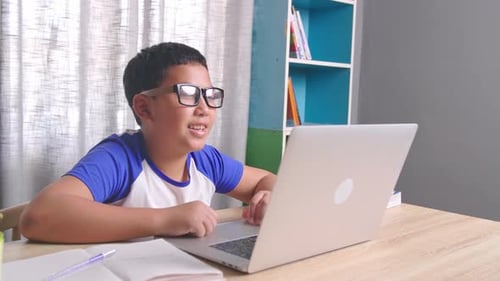 Boy Using Laptop for School at Home