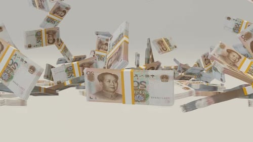 Many wads of money falling on table. 20 Chinese Yuan banknotes.