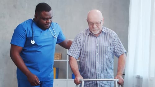 Supportive Caregiver Assists Senior Man with Walker