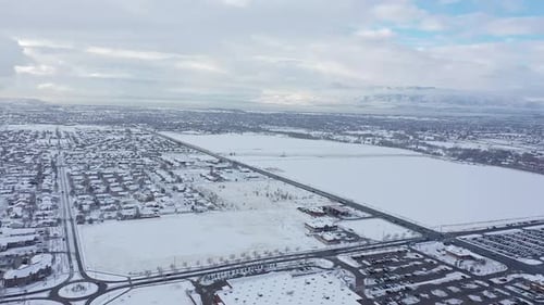Aerial view flying over snow covered valley viewing houses