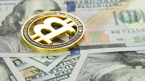 Gold Coin Bitcoin Close Up on the Background of Hundred Dollar Bills of Us Dollars