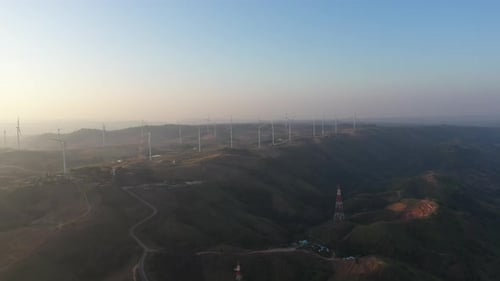 Aerial view of powerful Wind turbine farm for energy production on beautiful cloudy sky at highland.