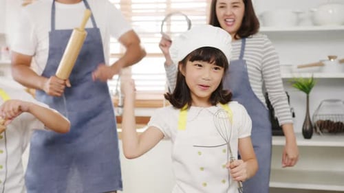 Happy Family Dancing in Kitchen with Baking Utensils