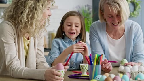 Video of happy girl with family coloring Easter egg, Shot with RED helium camera in 8K