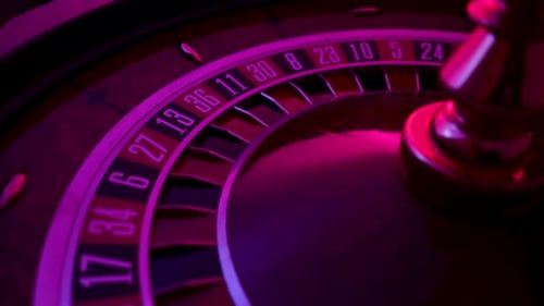 Rotating Roulette Wheel Close Up in the Rays of Purple Neon Lights