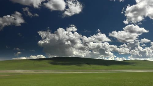 Wide Treeless Meadow Under Partly Cloudy Sky