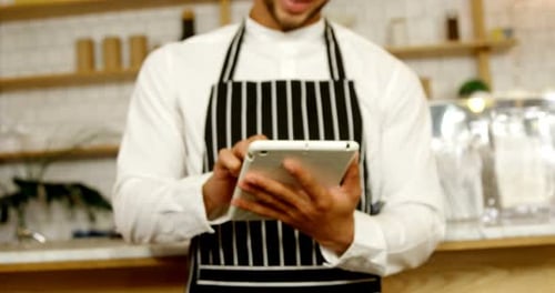 Smiling waiter using digital tablet 4 4k