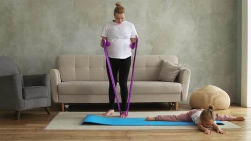 Pregnant Woman Works Out with Resistance Band at Home