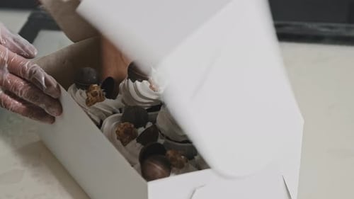 Woman Chef Put Decorated Cupcakes in the Cardboard Box