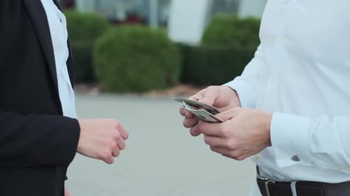 Business People Exchanging Money and Handshaking