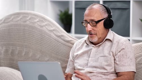 Senior Man Video Calling at Home on Laptop