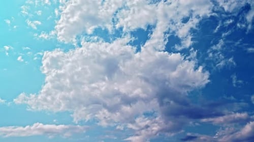Billowing Clouds Moving Across Open Blue Sky