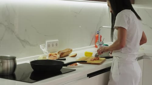 Woman Cooking Salmon in a Bright Modern Kitchen
