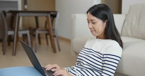 Woman Using Laptop Computer in Living Room