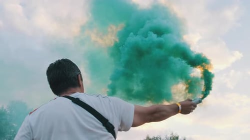 Adult Holding a Smoke Grenade Outdoors in Daytime