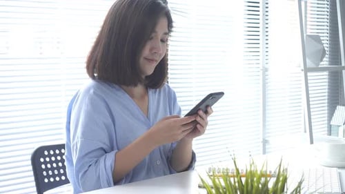 Young Woman Working at Desk by Window