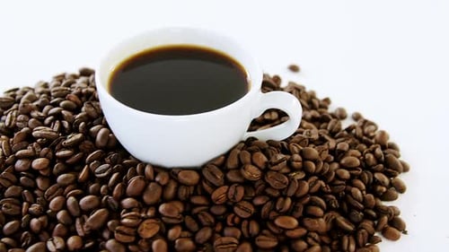 Cup of black coffee with roasted coffee beans