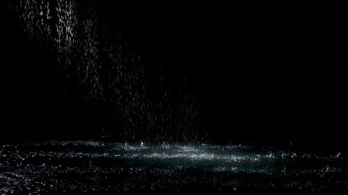 Sprühspritzer fallen gegen Regen auf die Wasseroberfläche, die glühen. Schwarzer Hintergrund. Weißes Neon