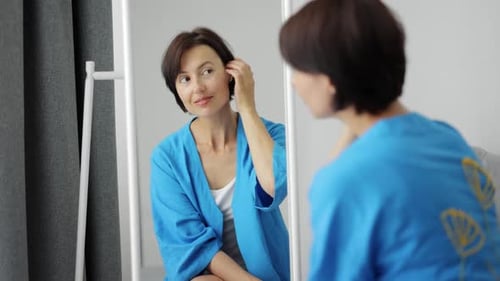 Woman Smiling in Mirror in Her Home
