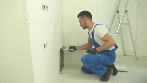 Man Repairing Wall with Plaster and Trowel