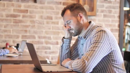 Young Man Sleeping While Working on Laptop