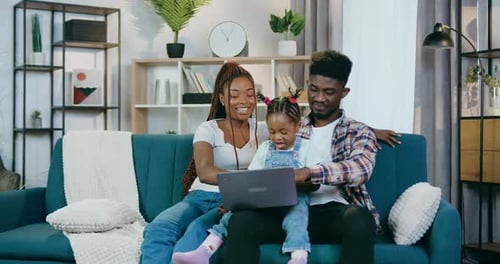 Familia afroamericana jugando juegos en una computadora portátil en casa