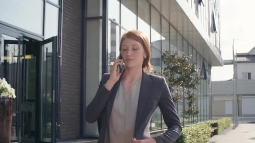 Woman Walking on Street and Talking on Phone