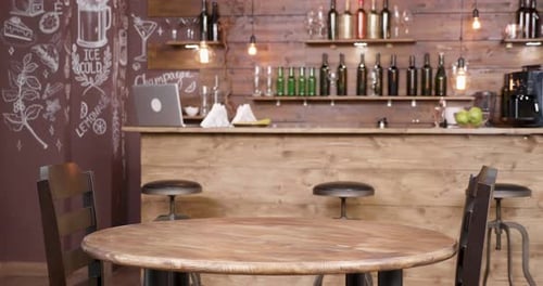 Parallax Shot of an Empty Table and Two Chairs in Front of a Bar