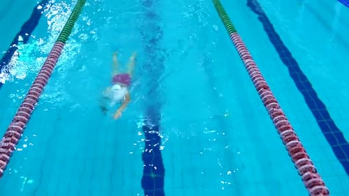 Professional Swimmer Practicing in Water Swimming Pool
