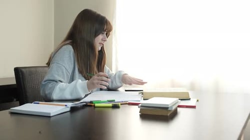 Young Adult Studying and Writing at Table