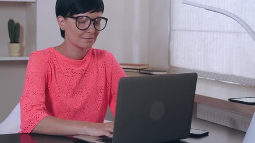 Female at Work Entering Data on Laptop