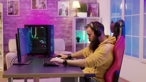 Young Adult Playing Computer Games At Home