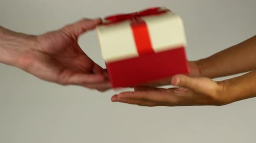 Hands Exchanging Birthday Gift Box Close Up
