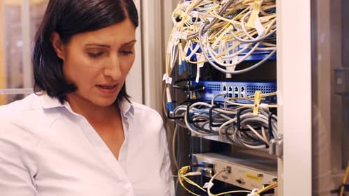Techniker überprüft Kabel in einem im Rack montierten Server