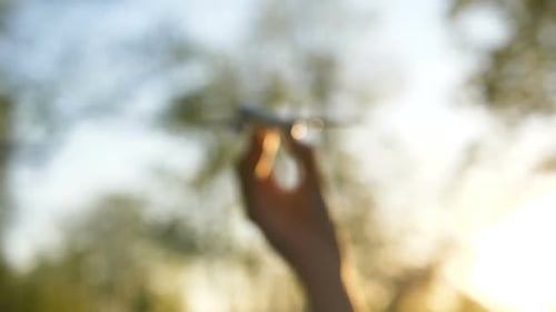 Hand Holding Model Airplane in Golden Sunlight