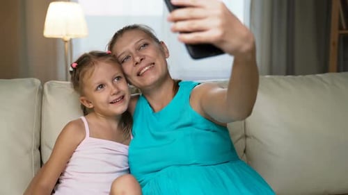 Mother and Daughter Take a Smiling Selfie Together