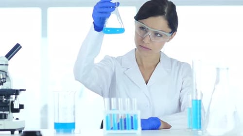 Woman Scientist Holding Blue Liquid in Lab