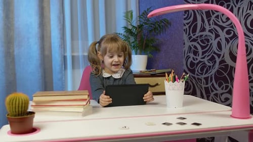 Child Girl Doing Homework Using Digital Tablet Computer at Home Back To School Online Learning