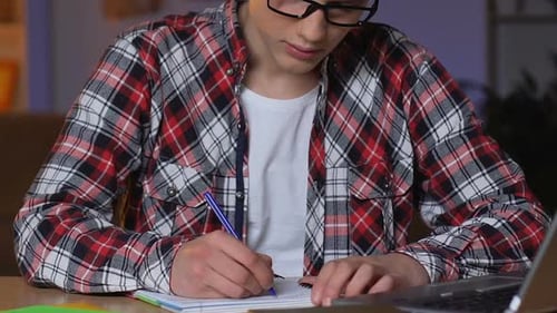 Tired Teenager Studying Hard at Home at Night