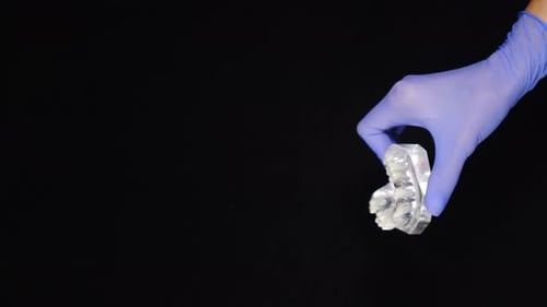 Hand Holds Dental Implant Model in Close Up