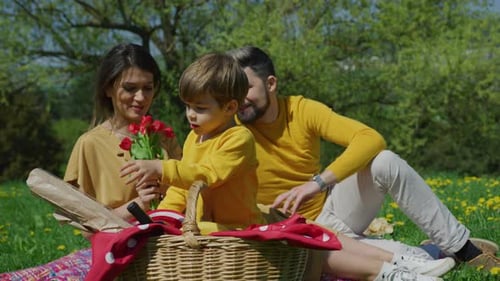 Family Picnic with Flowers in the Spring Park
