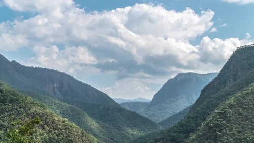 Timelapse of Clouds Moving Above Mountain Valley on Sunny Day