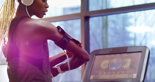 Woman on Treadmill at Gym Checks Smartwatch